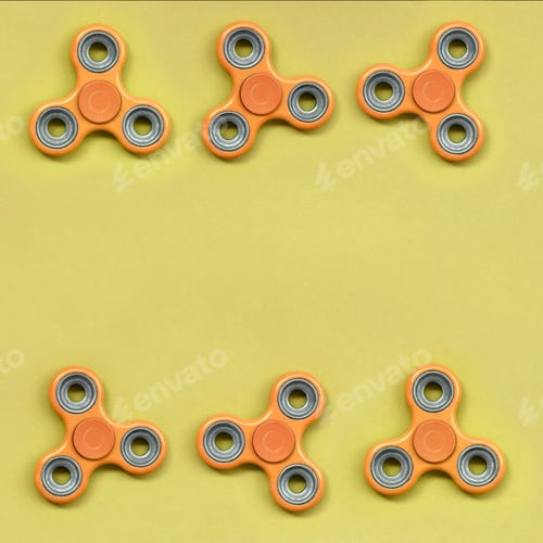 Preview: Many orange fidget spinners lies on texture background of fashion pastel orange color paper