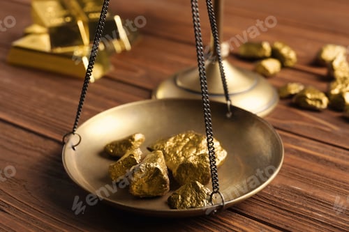 Preview: Scale pan with gold lumps on wooden table, closeup