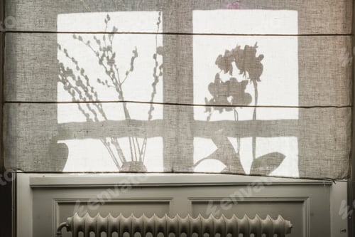 Preview: Shadows of plants cast on a translucent window shade with a radiator visible underneath.