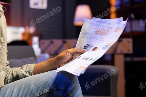 Preview: Focused person sitting on the couch and examining data driven files