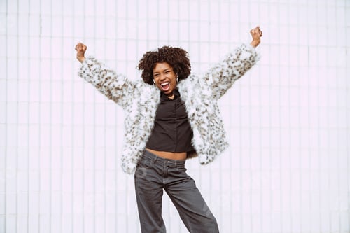 Preview: Excited Woman in Stylish Faux Fur Jacket Outdoors