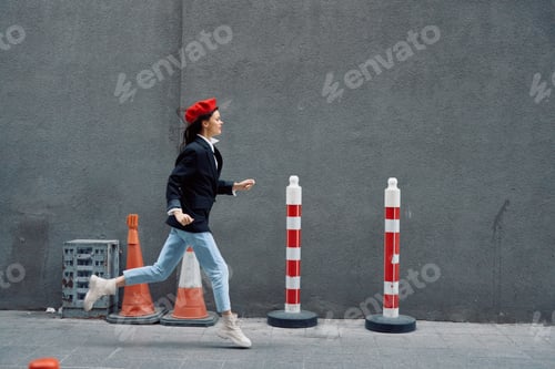 Preview: Fashion woman running down the street in front of the city tourist in stylish clothes with red lips