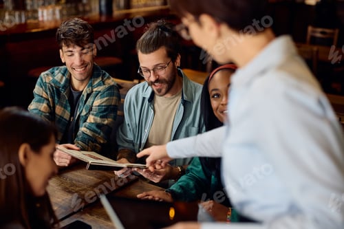 Preview: Happy friends choosing order from a menu with help of a waitress in a pub.