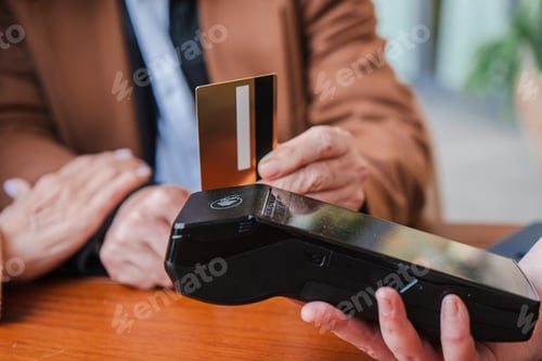 Preview: Unrecognizable customer making a payment with a credit card on a sleek electronic payment terminal
