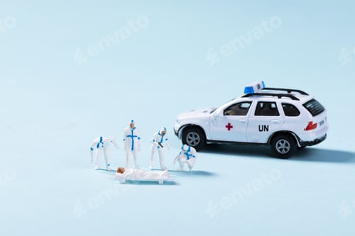 Preview: Closeup of toy ambulance and paramedics helping a patient