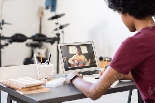 Preview: Young blackman with guitar teaching music on laptop screen