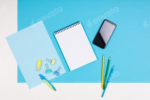 Preview: Mobile phone and different stationery isolated on whitte and blue background