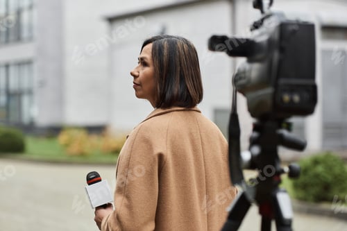 Preview: Woman with Microphone Standing in Front of Camera