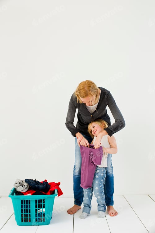 Preview: Studio shot of mother and daughter with dirty laundry