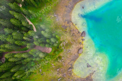 Preview: Aerial view of turquoise blue water of lake Carezza in Alps Dolomites. Lago di Karersee near fir