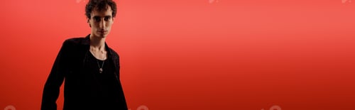 Preview: Handsome man showcasing elegant style with a confident pose against a vibrant backdrop