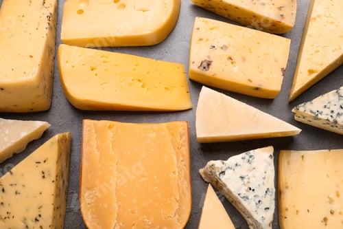 Preview: Different kinds of delicious cheese on stone background, top view