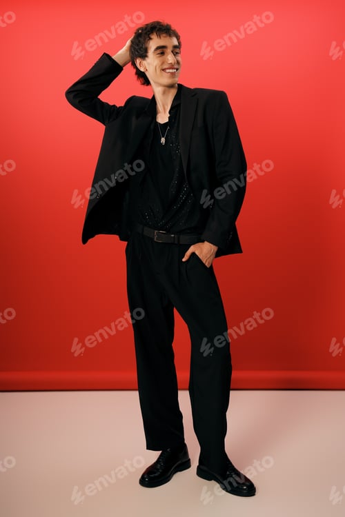 Preview: Stylish man exuding confidence and elegance against a vibrant red backdrop