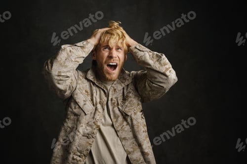 Preview: Unhappy military man with headache holding his head and screaming