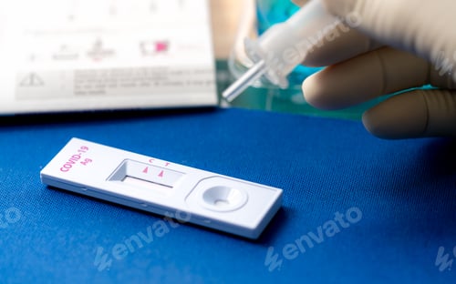 Preview: Hand holding sample tube and drops in the test device of covid 19 antigen self test. Antigen test