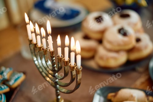 Preview: Menorah with lit candles on the table during Hanukkah.