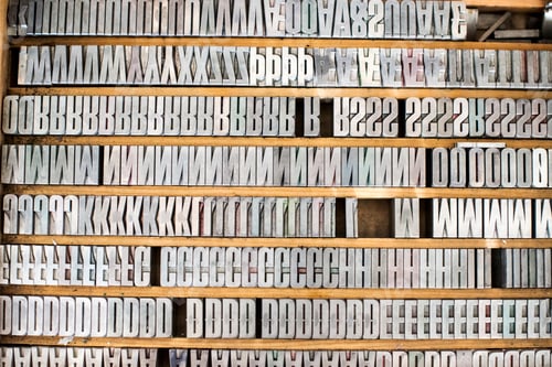Preview: Shelves of silver letterpress letters in print workshop