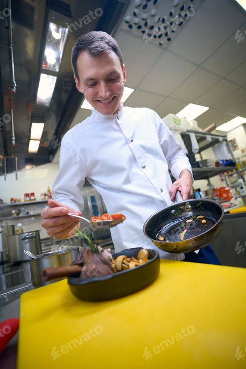 Preview: Young chef is preparing to serve lamb shank with vegetables