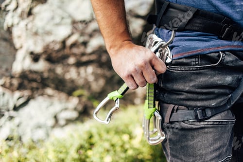 Preview: Rock Climber Holding Gear with Harness for Outdoor Adventure
