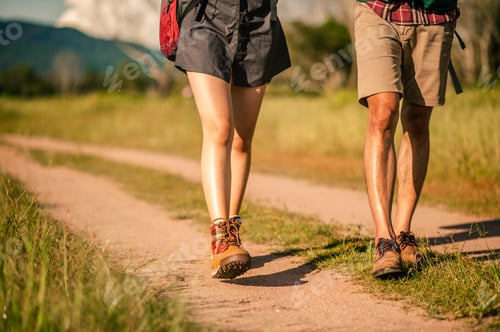 Preview: Hikers with backpacks walking trough forest path wearing mountain boots with focus on the shoes.