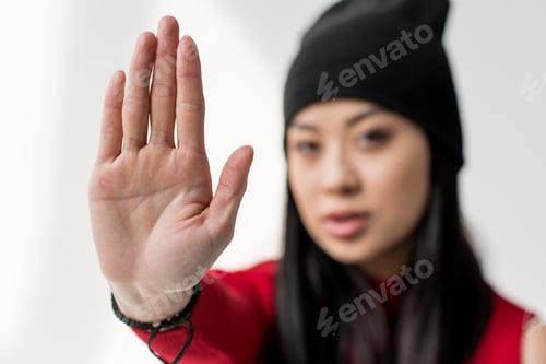 Preview: portrait of attractive asian woman showing stop sign isolated on grey