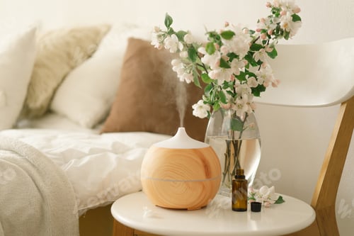 Preview: Aromatherapy Concept. Aroma oil diffuser on chair against in the bedroom. Air freshener.