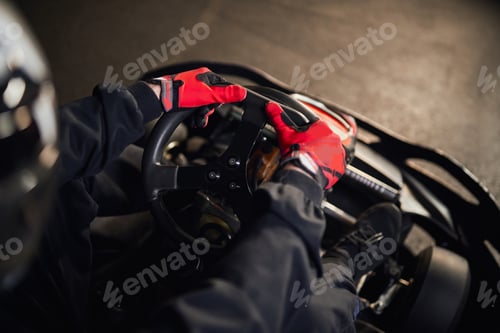 Preview: top view of racer in helmet driving go kart car on indoor circuit, motorsport competition concept