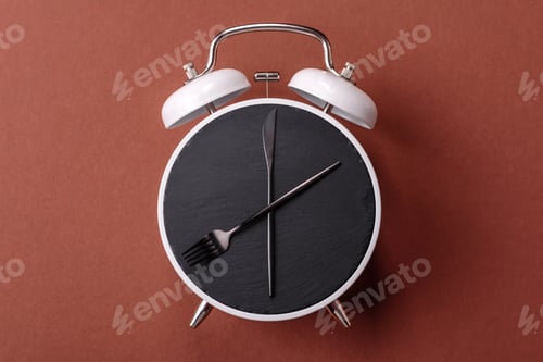 Preview: Empty plate with devices in the form of clock hands as a conceptual background for lunch time