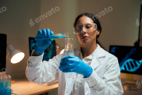 Preview: Woman scientist pouring chemical liquid in research lab