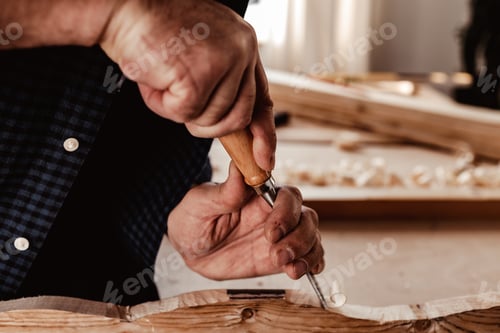 Preview: Hands of a carpenter working with chisel and hammer