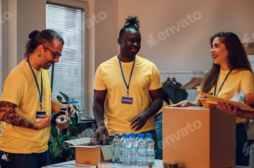 Preview: Group of multiracial volunteers working in community charity donation center