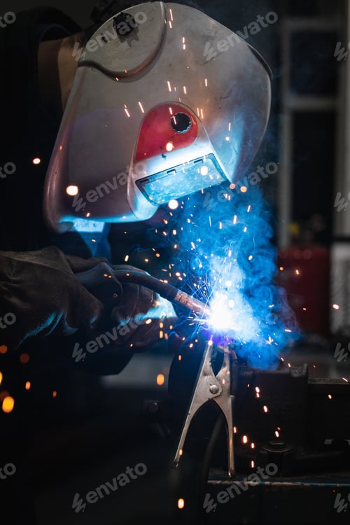Preview: Anonymous mechanic welding metal construction in workshop