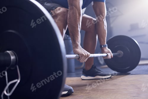 Preview: Shot of an unrecognisable man working out with a barbell at the gym