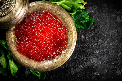 Preview: Full bowl of red caviar on the table.