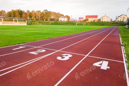 Preview: Aerial view of sports stadium with red running tracks with numbers on it and green grass football