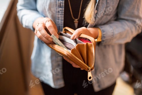 Preview: Person counting cash from their wallet