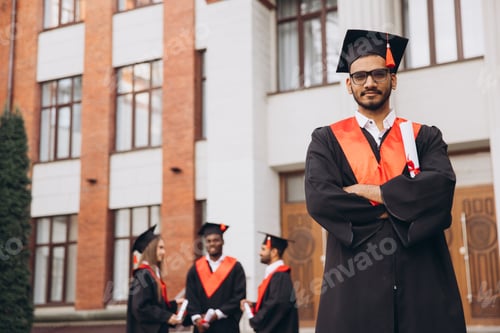 Preview: Group of Confident Graduates in Caps and Gowns Celebrating Success Outside University Building