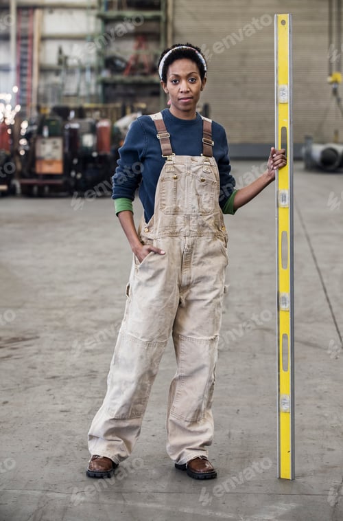 Preview: Black woman factory worker standing on the floor of a sheet metal factory.