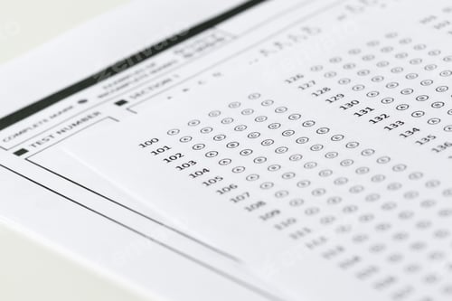 Preview: Test answer sheet with marked bubbles and answer choices in a classroom setting