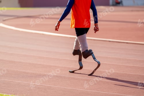 Preview: Asian para-athletes with prosthetic blades sprint on a running track at stadium.