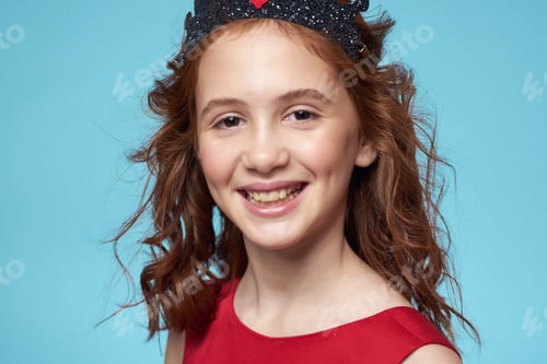 Preview: little girl with curly hair with a crown on her head red dress Smile blue background