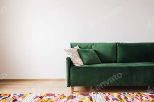 Preview: modern green sofa with pillows in spacious room with colorful rug