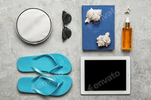 Preview: Flat lay composition with tablet and beach objects on light background