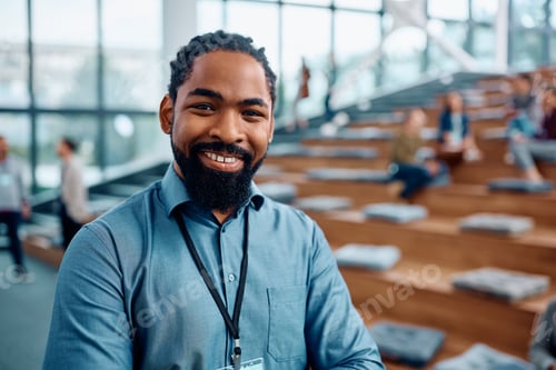Preview: Happy black businessman attending an education event in convention center and looking at camera.