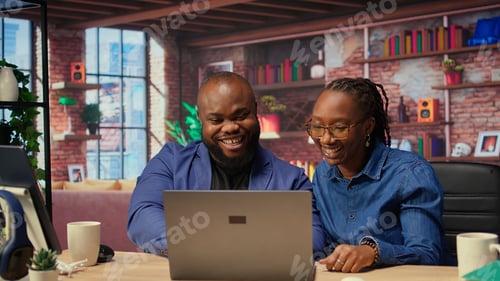 Preview: Young remote workers exchanging a high five being happy with their success