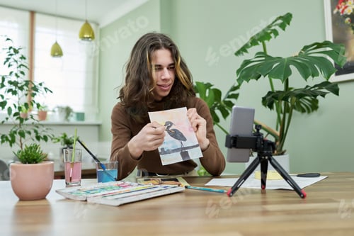 Preview: Guy teenager student drawing online using smartphone.