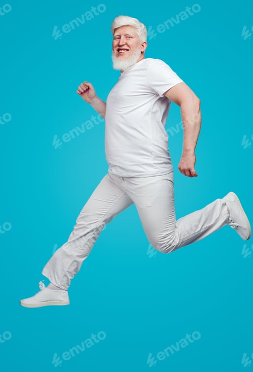 Preview: Cheerful albino man in white clothes running on blue background