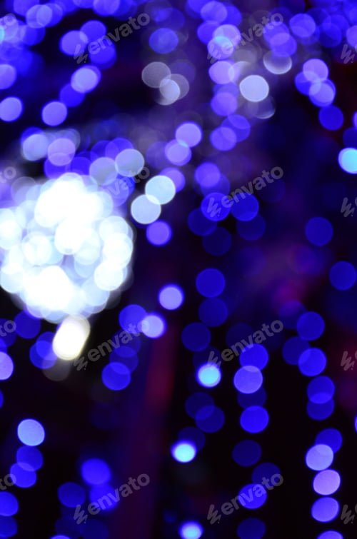 Preview: Blurred fragment of the New Year tree. Lots of round lights in blue