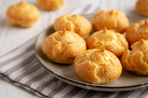 Preview: Homemade French Mini Cream Puffs on a Plate, side view.