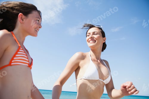 Preview: mother with daughter running along beach